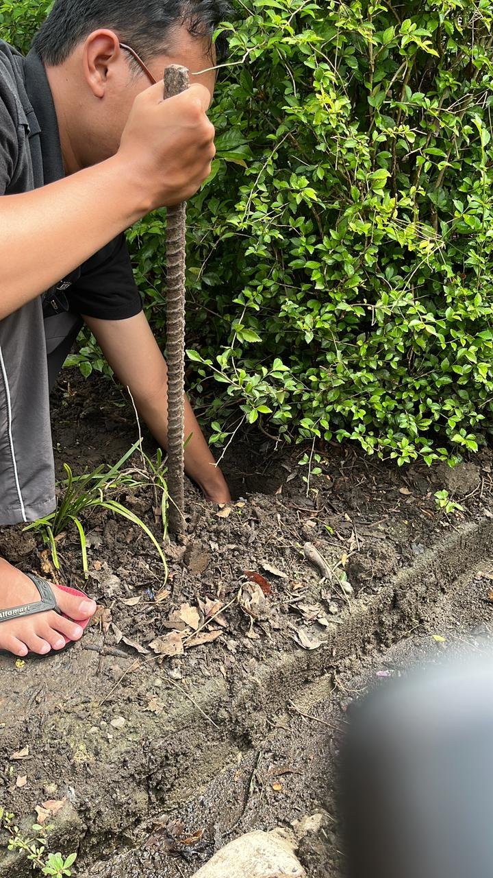 Membantu warga sekitar memasang tiang lampu