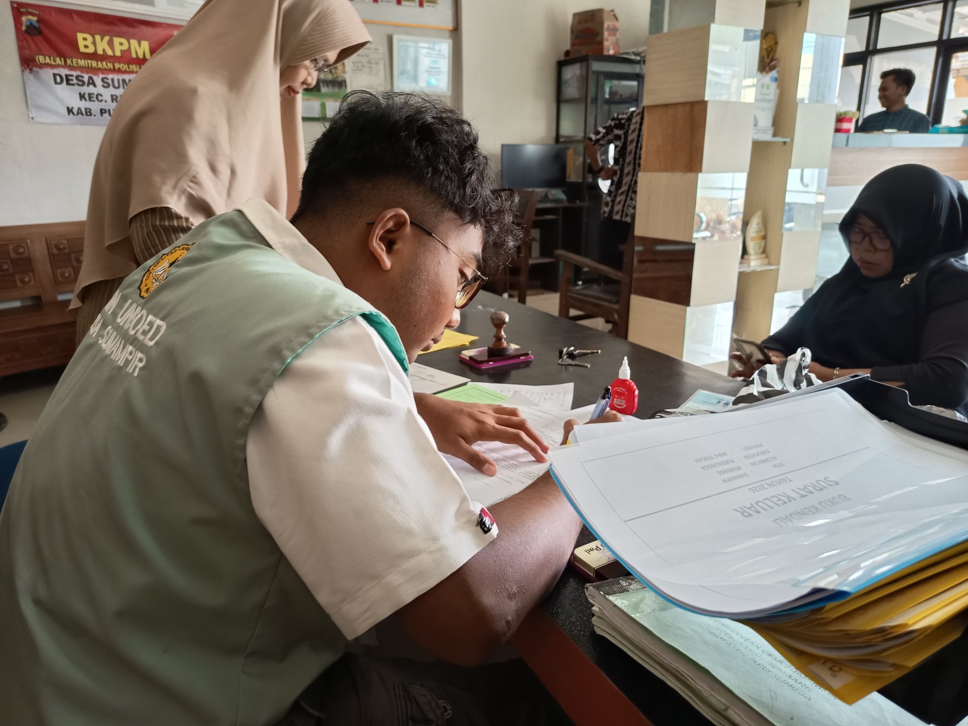 Melakukan piket pelayanan di Balai Desa Sumampir