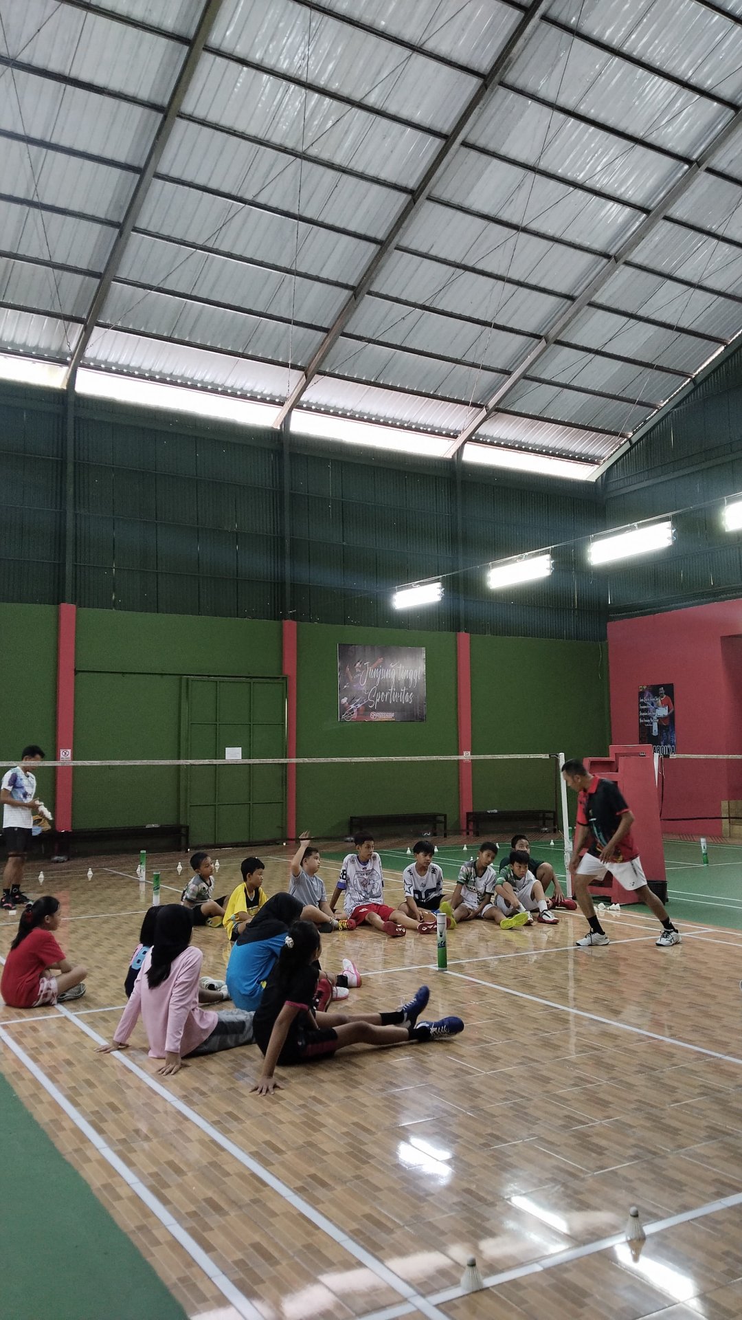 Mendampingi latihan rutin klub badminton