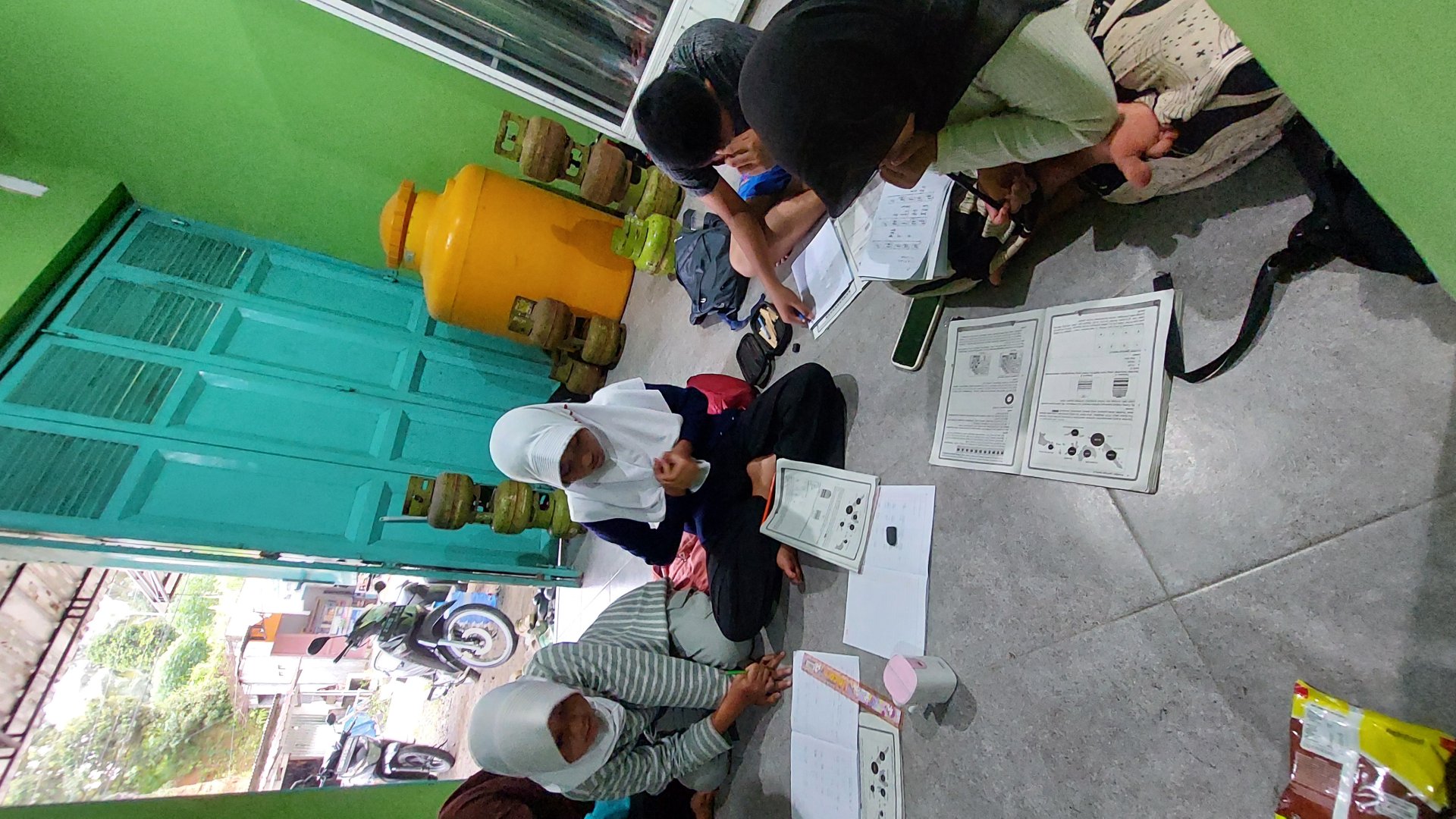 Membantu anak-anak sekitar posko untuk mengerjakan PR